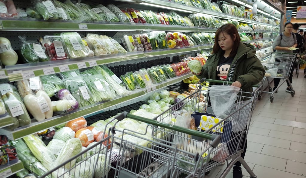 A woman selects vegetables at a supermarket in Beijing on November 9, 2019. China recorded some growth in retail sales in the last quarter of 2019. Photo: EPA-EFE