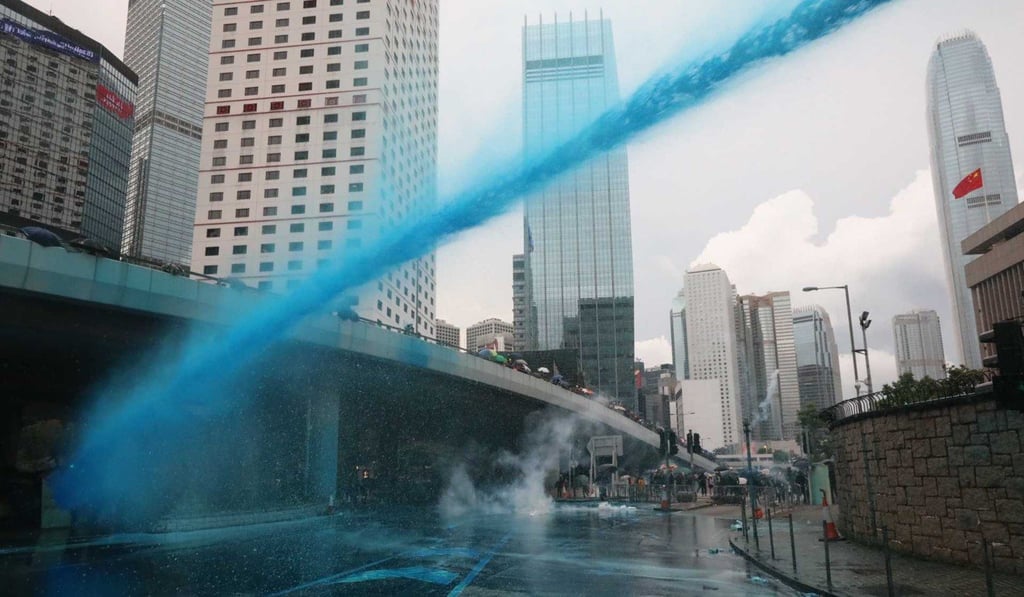 Police water cannon fires blue dyed water at anti-government protesters in Admiralty. Photo: Felix Wong