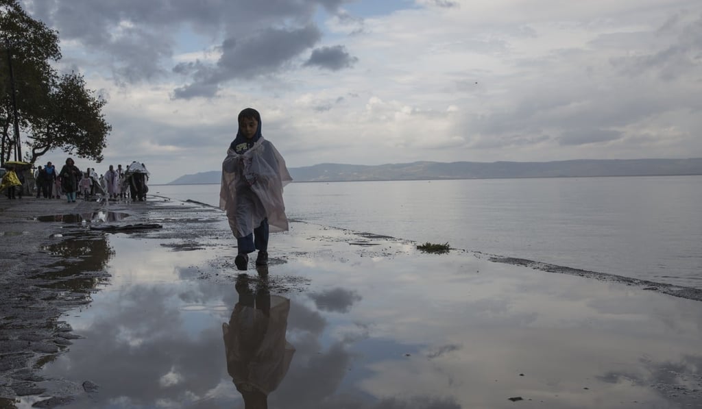 Refugees and migrants walk along the short following their arrival at Skala Sikamias, Lesbos island, Greece. Photo: AP