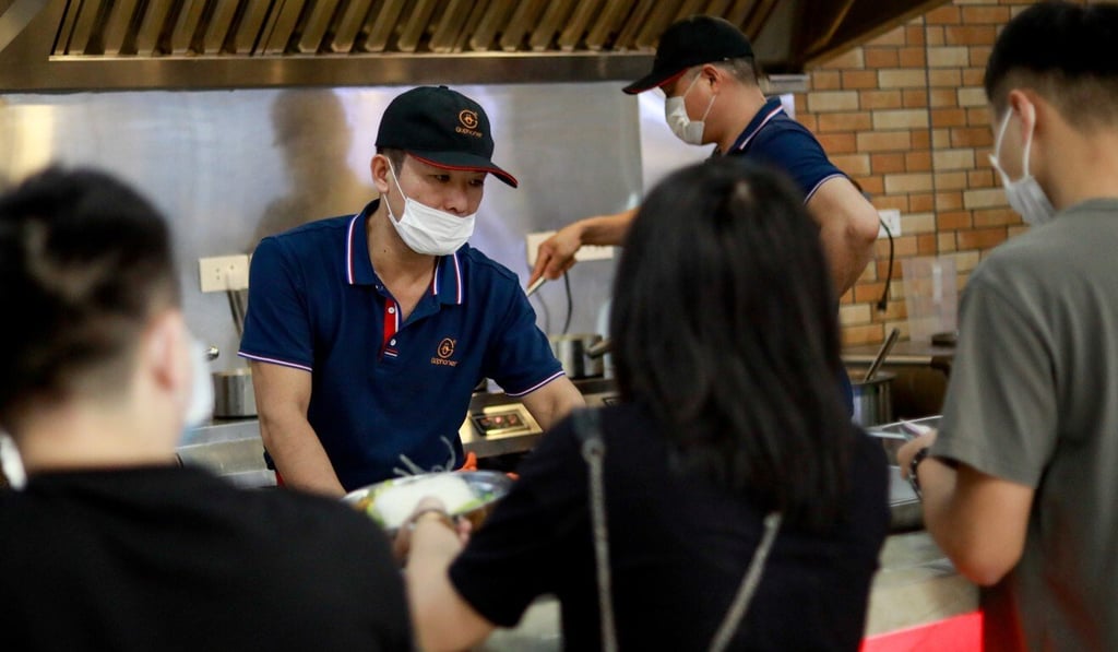 Workers wear masks while serving at a restaurant in Paranaque, the Philippines. Photo: Reuters