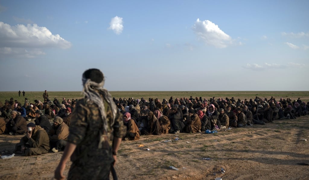 US-backed Syrian Democratic Forces fighters guard suspected Islamic State militants near Baghouz, eastern Syria. Photo: AFP