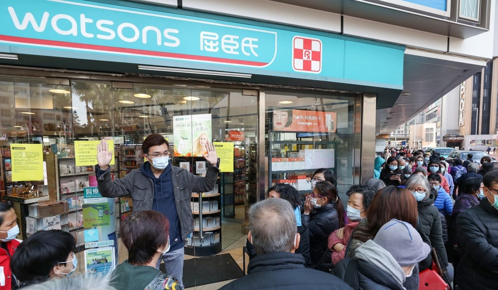 A Watsons employee speaks to customers queuing for masks at a store in Whampoa. Photo: Nora Tam