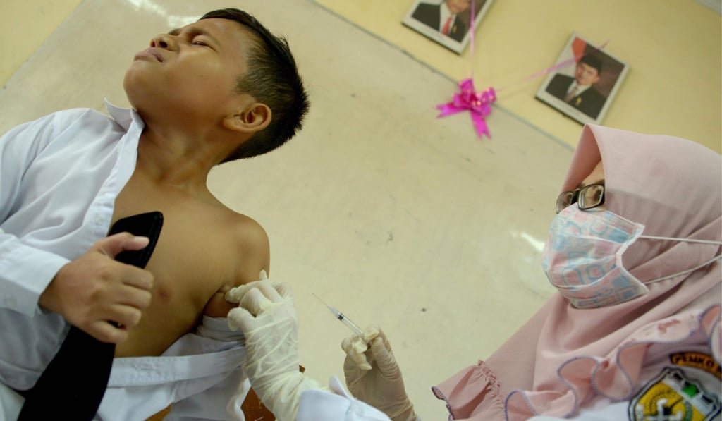 A nurse vaccinates an Indonesian schoolboy at his school in Banda Aceh. Photo: AFP