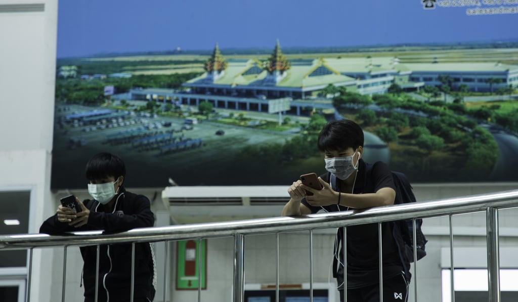 Young men wearing masks look at their phones at Mandalay Airport in Myanmar. Photo: Yan Moe Naing Young men wearing masks look at their phones at Mandalay Airport in Myanmar. Photo: Yan Moe Naing