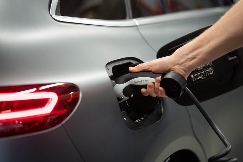 A worker charges a Mercedes-Benz electric car. Photo: EPA-EFE