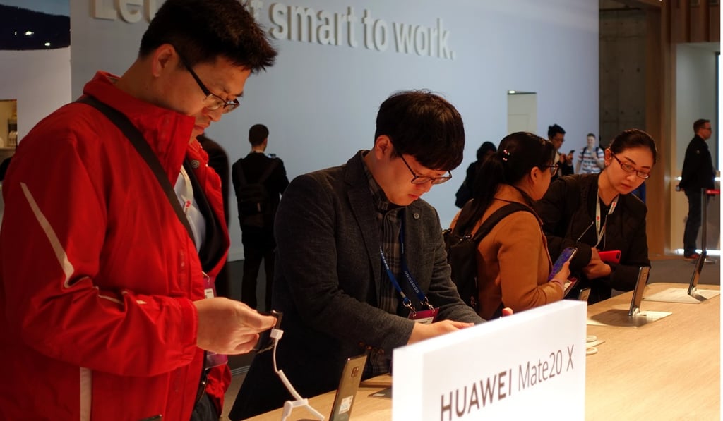 Visitors check out smartphones on display in the booth of Huawei Technologies at trade show MWC Barcelona in Spain in February of last year. Photo: Xinhua