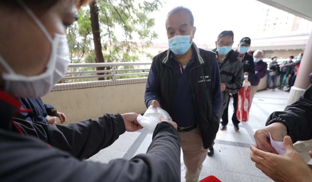 A man receives surgical masks in exchange for a voucher at a Circle K shop in Hong Kong’s Sheung Shui neighbourhood. Photo: Winson Wong