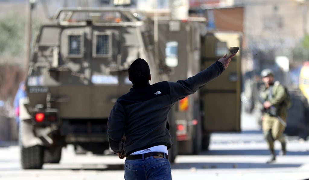 Palestinians throw stones at Israeli troops during clashes following a raid in the West Bank city of Beit Jala. Photo: EPA-EFE Palestinians throw stones at Israeli troops during clashes following a raid in the West Bank city of Beit Jala. Photo: EPA-EFE