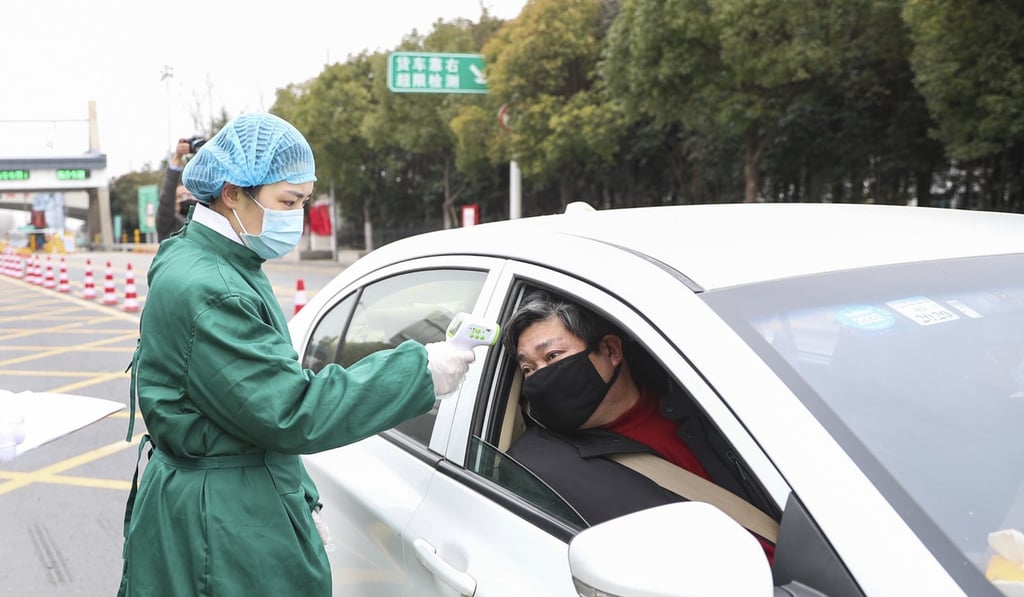 A doctor in China’s Jiangsu province uses a thermometer to check a driver’s temperature as a precautionary measure to prevent the spread of coronavirus. Photo: DPA A doctor in China’s Jiangsu province uses a thermometer to check a driver’s temperature as a precautionary measure to prevent the spread of coronavirus. Photo: DPA