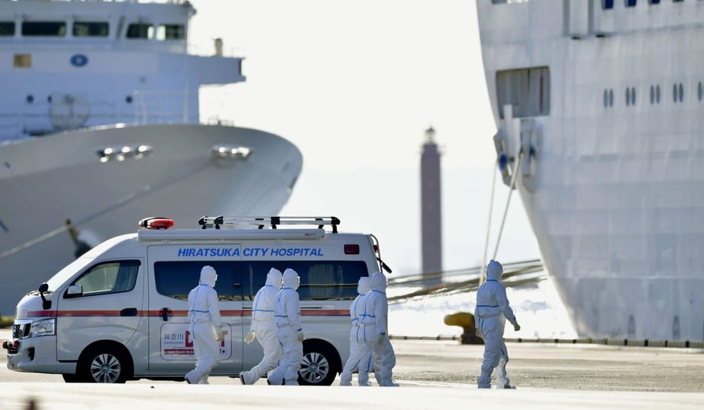 Medical workers in protective suits walk towards the Diamond Princess cruise ship docked in Yokohama on Tuesday. Photo: Kyodo