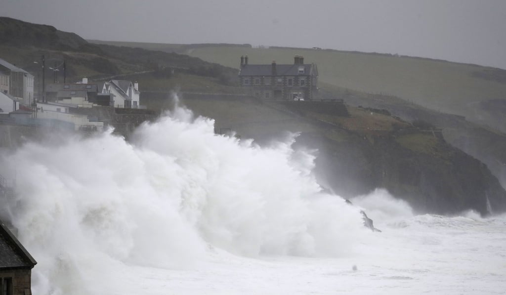 Powerful waves break on the shoreline around the small port of Porthleven, south west England, as Storm Dennis hits Britain. Photo: AP