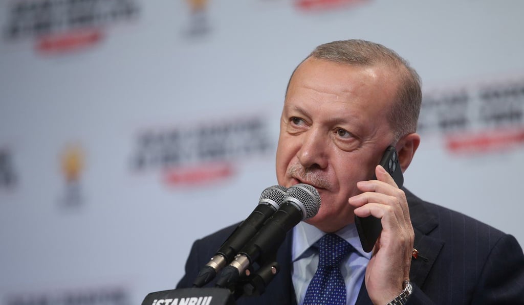 Turkish President Tayyip Erdogan talks to phone as he addresses his ruling AK Party members in Istanbul. Photo: Handout via Reuters