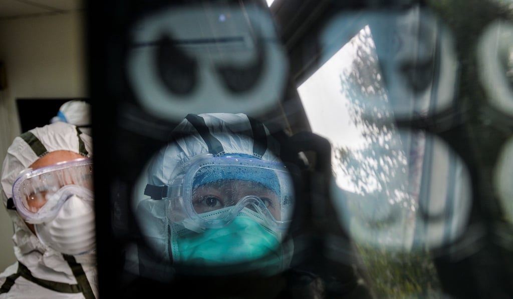 Medical workers in protective suits check a CT scan image of a patient at a community health service centre in Wuhan. Photo: Reuters