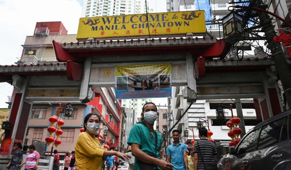 People wearing face masks walk through Manila’s Chinatown district of Binondo. Photo: AFP