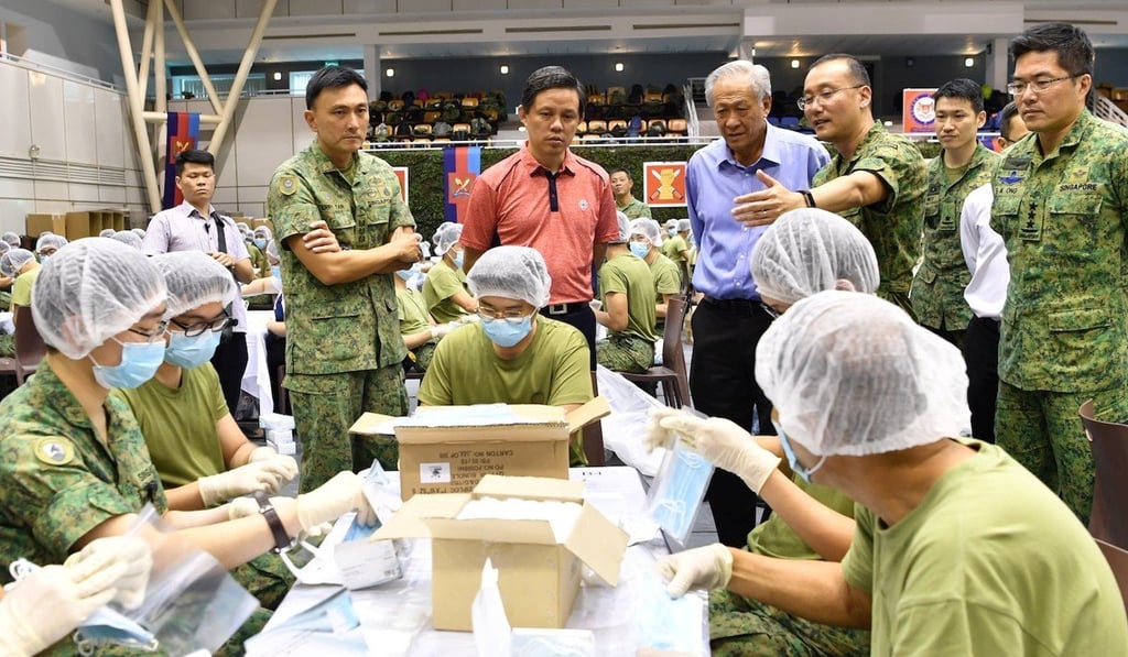 Singapore Minister for Trade and Industry Chan Chun Sing, centre, looks on as army personnel prepare face masks for distribution on January 31. Photo: Reuters