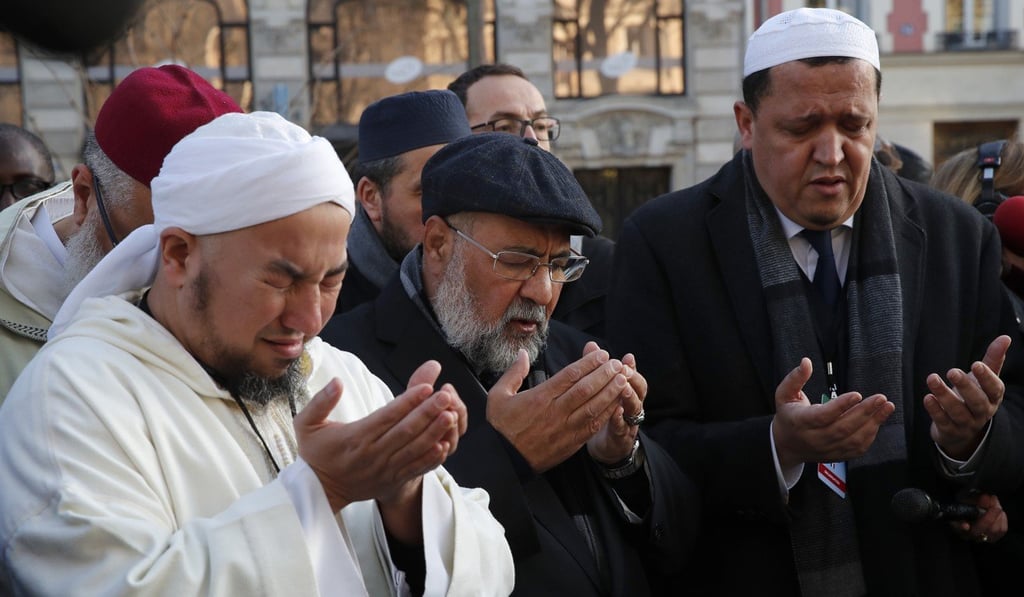 Imam Hassen Chalghoumi (right) and a group of imams from Europe pray on Tuesday in front of the Bataclan concert hall during a tribute for victims of the November 2015 Paris attacks. Photo: AP Imam Hassen Chalghoumi (right) and a group of imams from Europe pray on Tuesday in front of the Bataclan concert hall during a tribute for victims of the November 2015 Paris attacks. Photo: AP