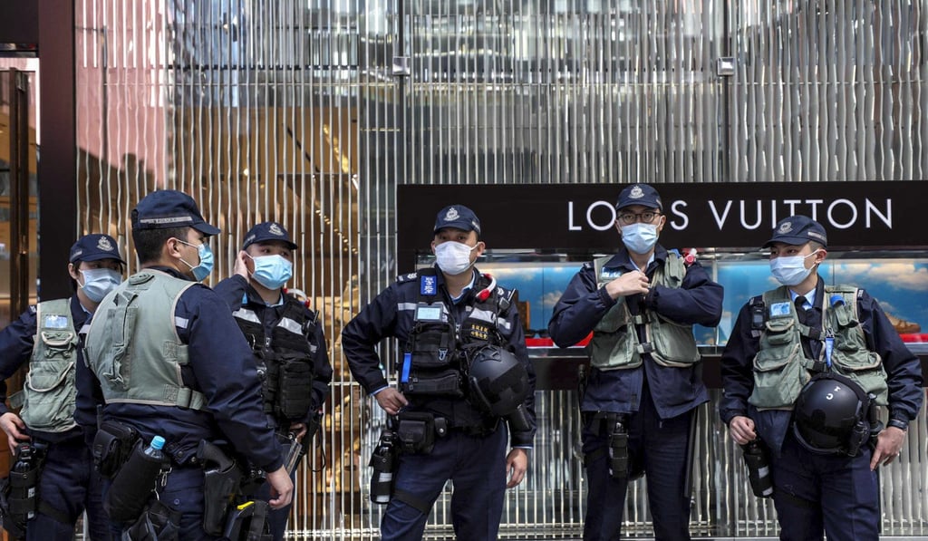 Anti-riot police monitor anti-government protesters in Central at a lunchtime rally to commemorate the July 21 Yuen Long mob attack. Photo: Xiaomei Chen Anti-riot police monitor anti-government protesters in Central at a lunchtime rally to commemorate the July 21 Yuen Long mob attack. Photo: Xiaomei Chen