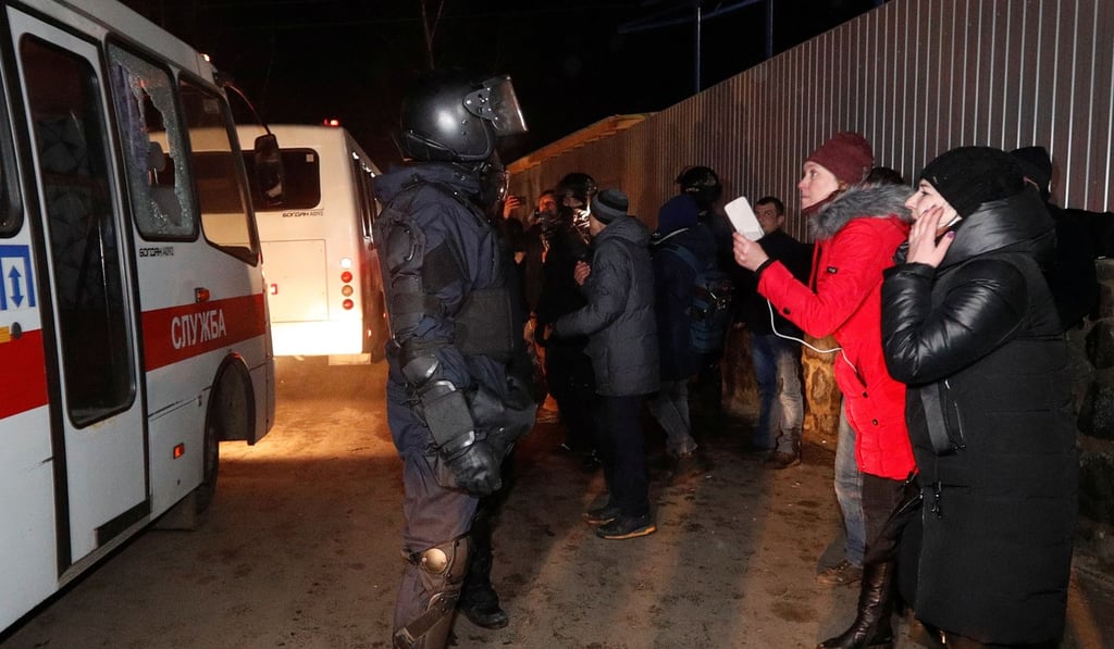 Buses transporting evacuees from China drive past demonstrators near the Ukrainian village of Novi Sanzhary on Thursday. Photo: Reuters Buses transporting evacuees from China drive past demonstrators near the Ukrainian village of Novi Sanzhary on Thursday. Photo: Reuters