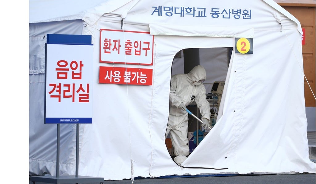 Workers erect a temporary negative-pressure quarantine room to accommodate suspected coronavirus patients waiting for their test results, at a hospital in Daegu. Photo: EPA-EFE