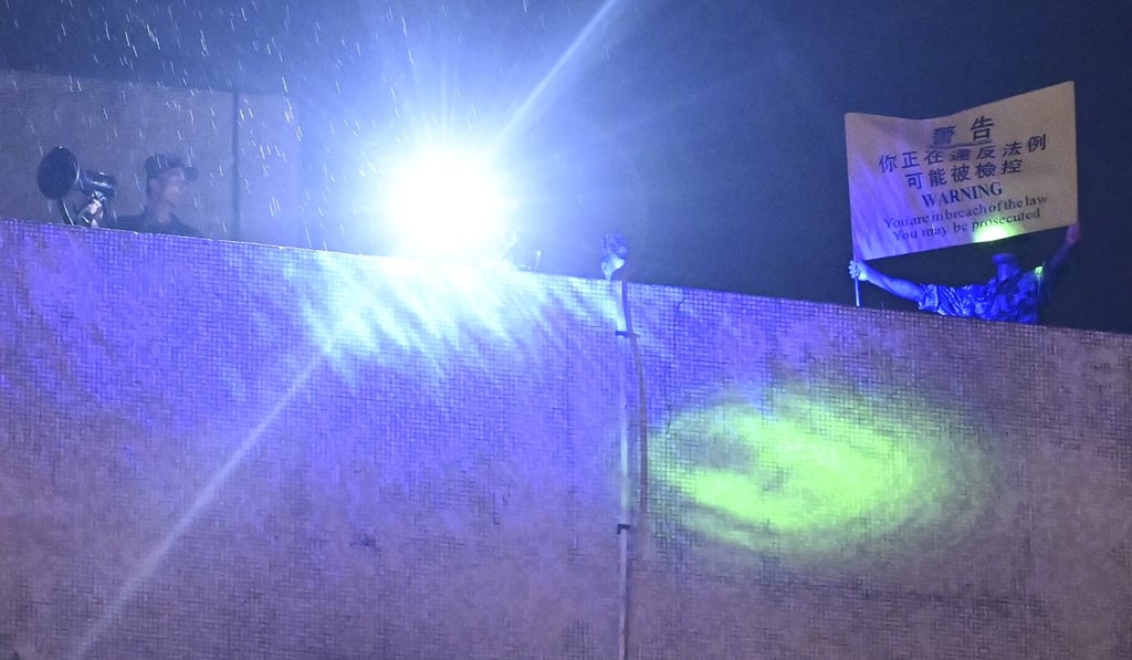 PLA soldiers raising a yellow flag to warn a crowd to leave the area of the PLA's Kowloon East Barracks in Kowloon Tong during anti-government protests last year. Photo: Handout