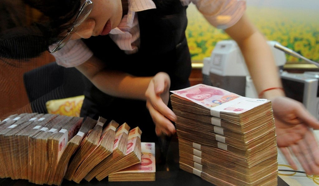 A teller counts yuan banknotes at a China Merchants Bank branch in Hefei, Anhui province. Photo: Reuters