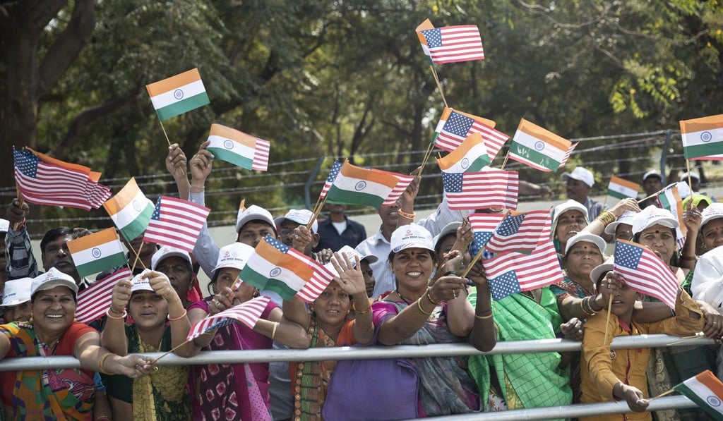 People line the street and wave flags as the motorcade for US President Donald Trump heads to a ‘Namaste Trump’ event in Ahmedabad on Monday. Photo: AP People line the street and wave flags as the motorcade for US President Donald Trump heads to a ‘Namaste Trump’ event in Ahmedabad on Monday. Photo: AP
