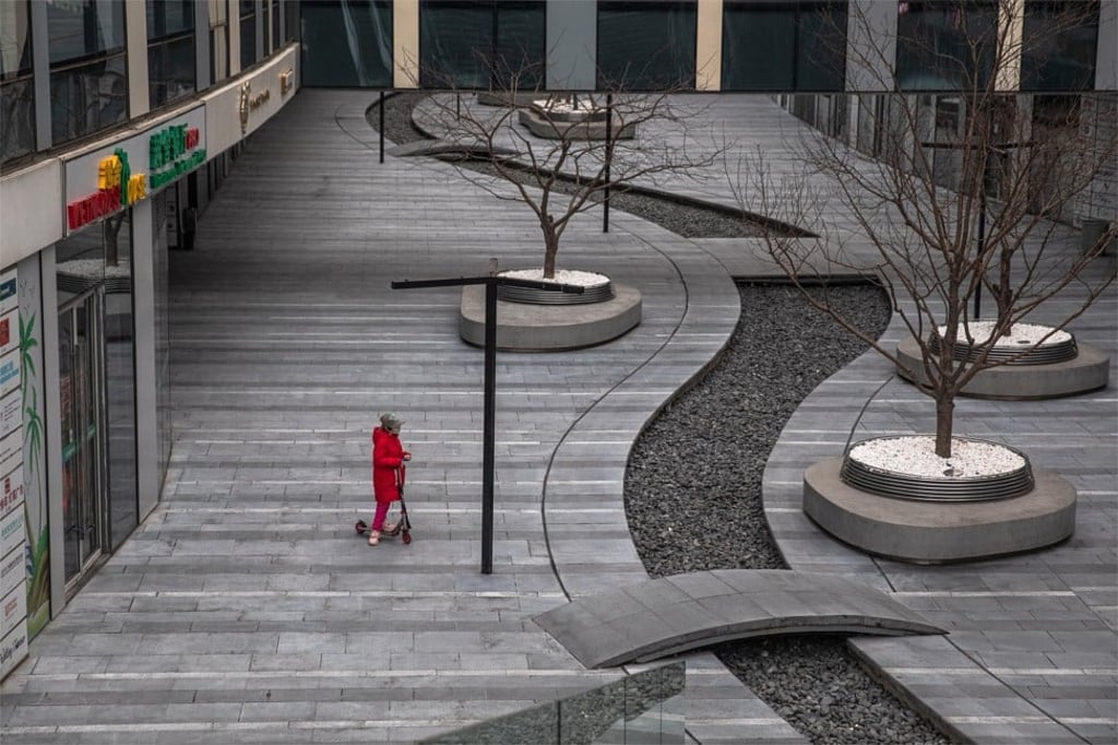 A child with a protective mask riding on a scooter in a deserted shopping centre in Beijing’s Sanlitun on 26 February 2020, on what should otherwise be a bustling week day in one of the busiest areas of the Chinese capital. Photo: EPA-EFE