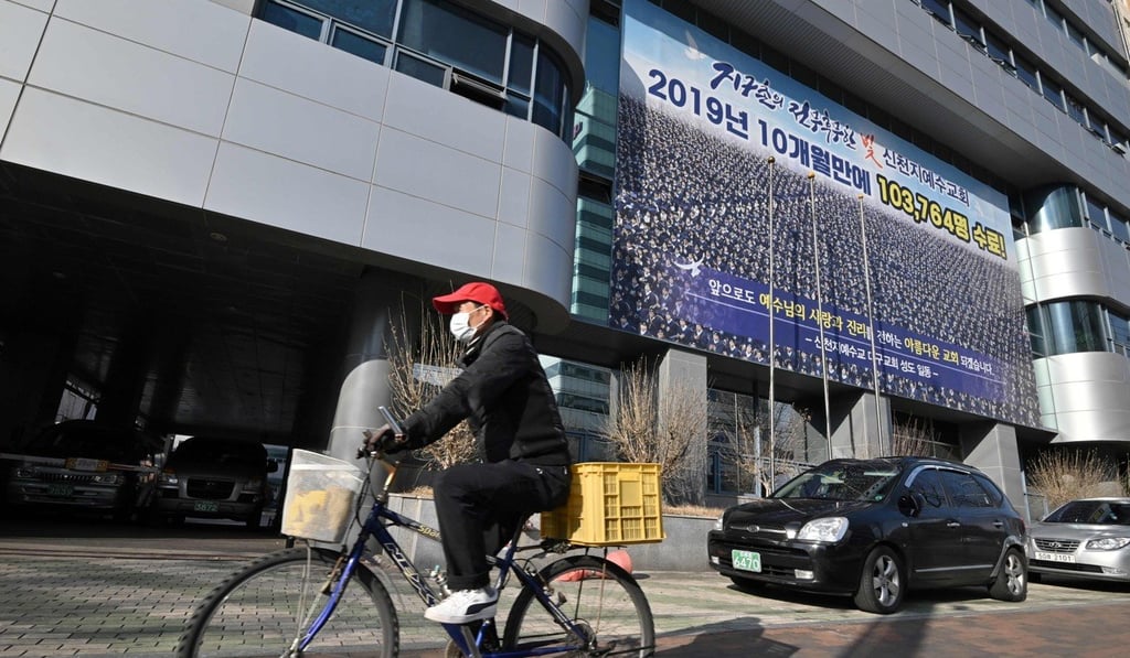 A man wearing a face mask rides a bicycle in front of the Daegu branch of the Shincheonji Church of Jesus. Photo: AFP