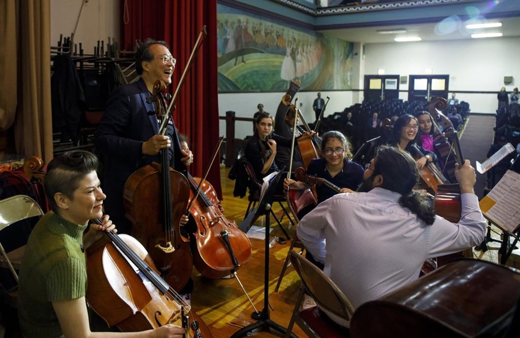 Ma greets students and Civic Orchestra of Chicago members as they play together at Chopin Elementary School in Chicago. Photo: TNS