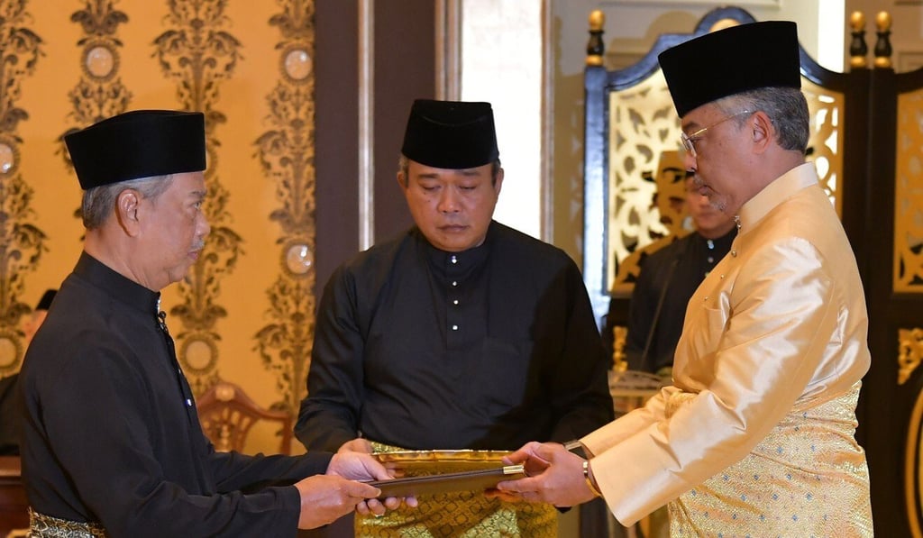 Malaysia's incoming Prime Minister Muhyiddin Yassin (left) receives documents from King Malaysia's incoming Prime Minister Muhyiddin Yassin (left) receives documents from King