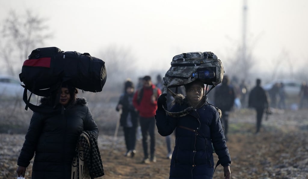 Migrants walk to reach a border gate at the Turkish-Greek border on Sunday. Photo: AP Migrants walk to reach a border gate at the Turkish-Greek border on Sunday. Photo: AP