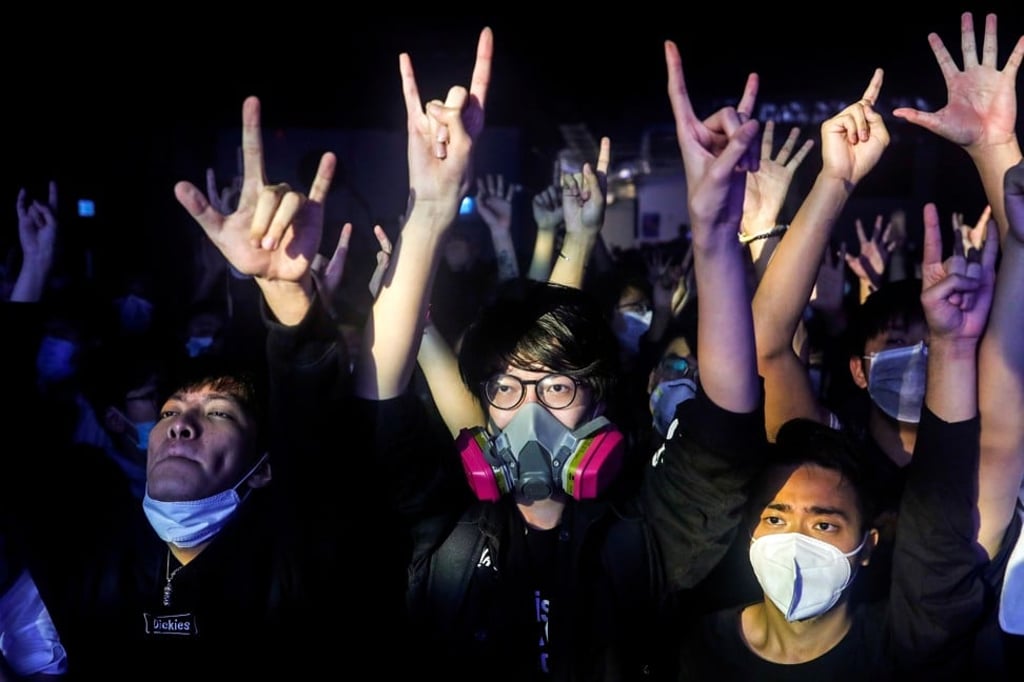 Fans wearing protective masks react while enjoying a band’s performance at Hidden Agenda: This Town Needs (TNN). Photo: Reuters