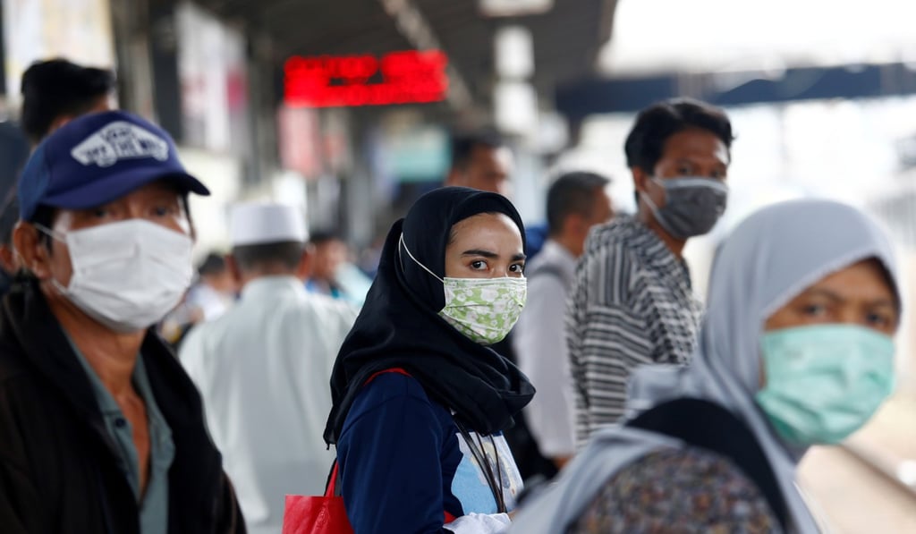 People wearing surgical masks as protection against the coronavirus at a railway station in Jakarta. Photo: Reuters