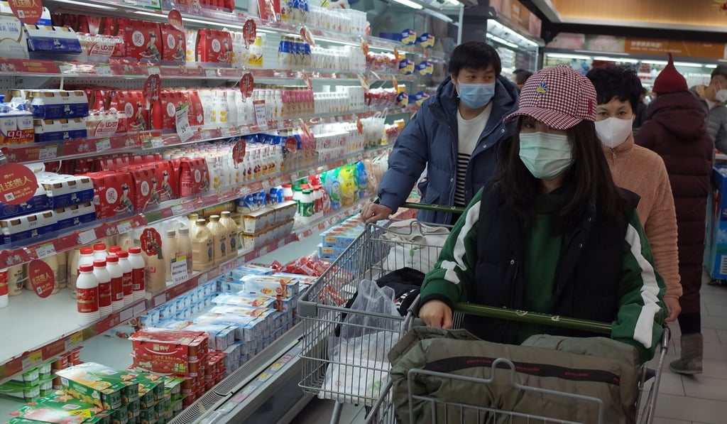 People shop in a supermarket in Beijing on February 2. During the coronavirus epidemic, Chinese consumers have been largely buying essential goods, with spending on services like entertainment and education in decline. Photo: EPA-EFE
