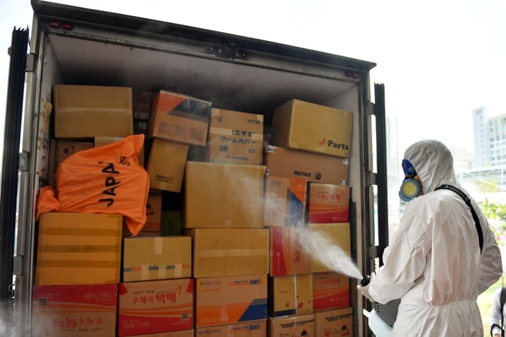 A postal officer disinfects packages in Bangkok on March 5, 2020. Photo: Reuters A postal officer disinfects packages in Bangkok on March 5, 2020. Photo: Reuters