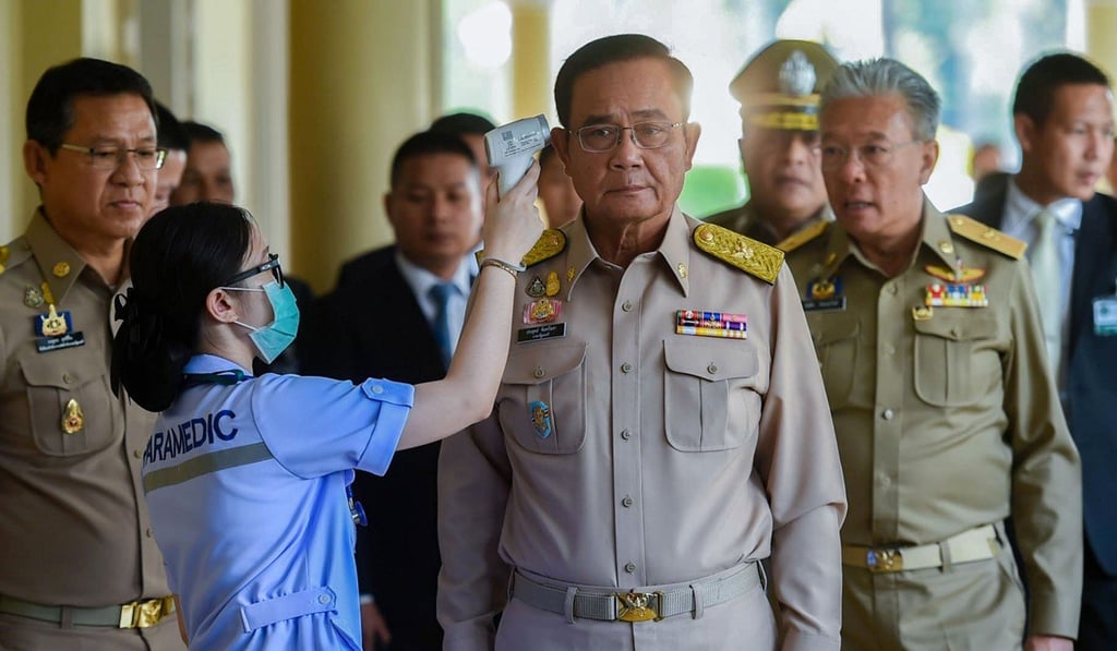 A paramedic checks the temperature of Thailand Prime Minister Prayuth Chan-ocha at the Government House in Bangkok on March 2, 2020. Photo: Handout/AFP