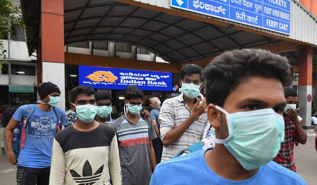 People wear face masks as a preventive measure against the spread of the Covid-19 coronavirus outbreak at the Bangalore City Railway Station. Photo: AFP