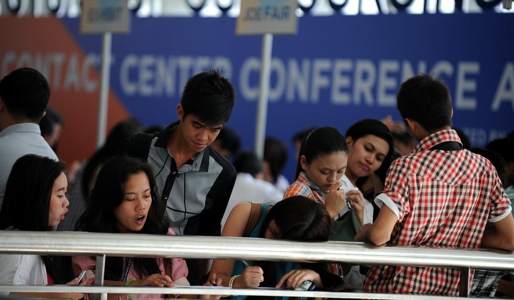 Jobseekers fill in forms at a job fair for call-centre agents in Manila. Photo: AFP