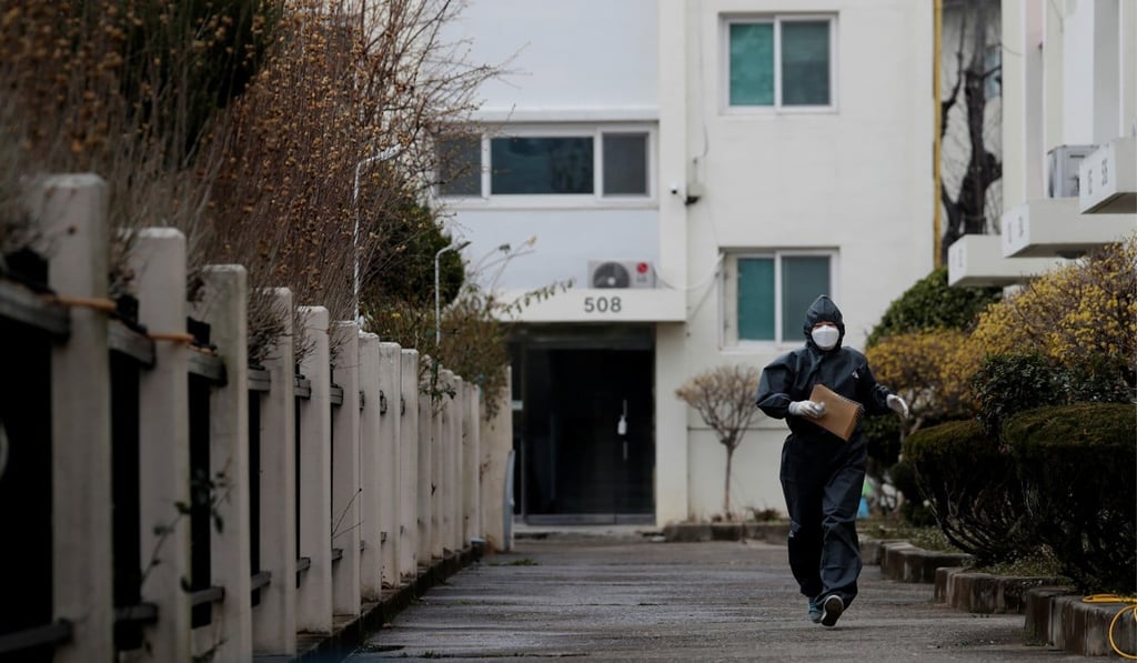 A health worker seen at a residential building where 46 people tested positive for the coronavirus. Photo: Reuters