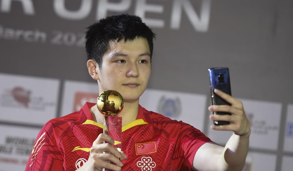 China’s men’s singles champion Fan Zhendong takes a selfie while on the podium in Doha. Photo: Xinhua China’s men’s singles champion Fan Zhendong takes a selfie while on the podium in Doha. Photo: Xinhua