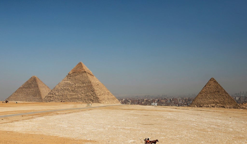 Tourists ride a horse-drawn cart in front of the Great Pyramids of Giza, on the outskirts of Cairo. Photo: Reuters Tourists ride a horse-drawn cart in front of the Great Pyramids of Giza, on the outskirts of Cairo. Photo: Reuters