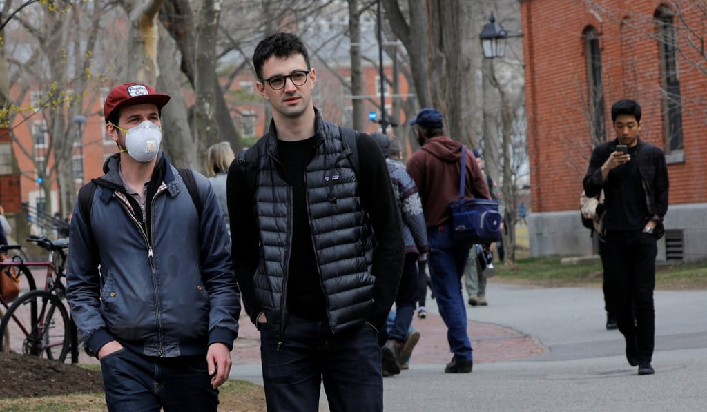 A student wears a mask as he walks across the Harvard University campus on Tuesday. Photo: Reuters