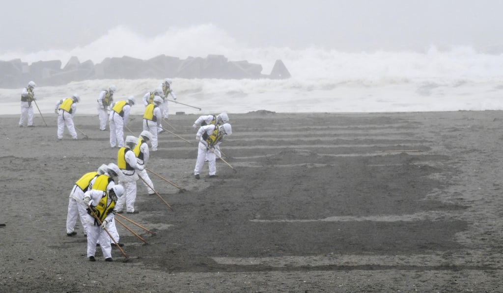 Police officers search a beach earlier this year for the remains of people who went missing in the earthquake and tsunami. Photo: Kyodo