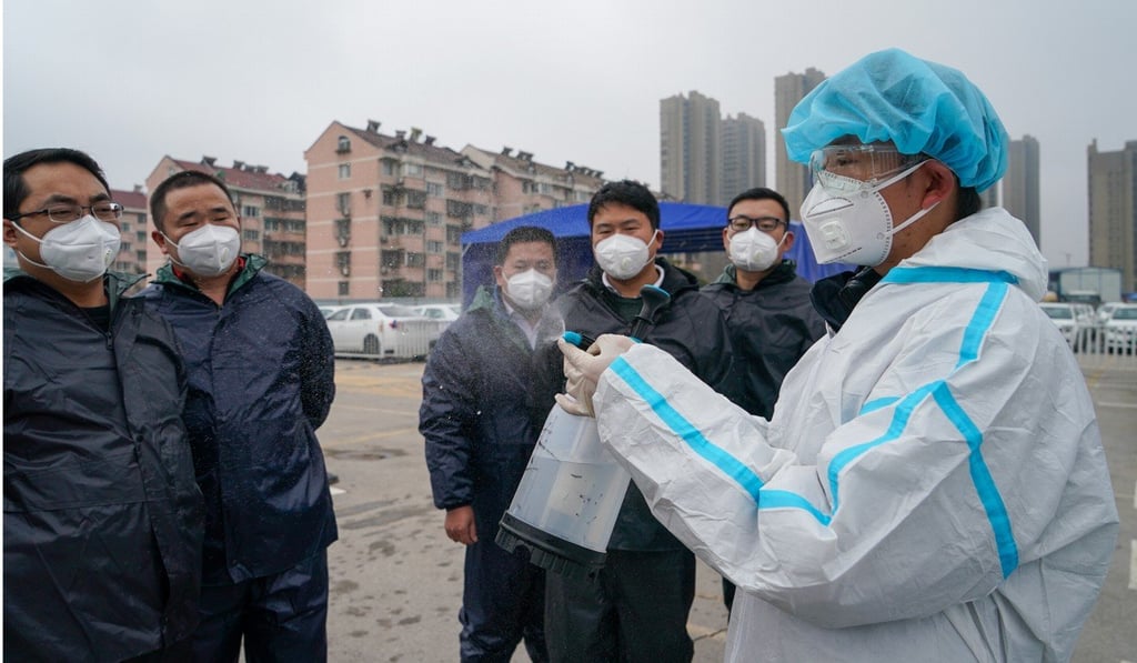 Didi Chuxing staff member shows drivers how to use a spray bottle to disinfect their vehicles in Nanjing, Jiangsu province. Photo: Xinhua