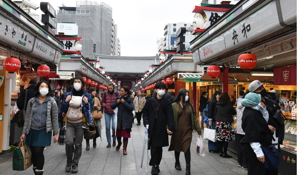 Pedestrians wear protective masks while walking past stores in the Asakusa district of Tokyo. Photo: Bloomberg Pedestrians wear protective masks while walking past stores in the Asakusa district of Tokyo. Photo: Bloomberg