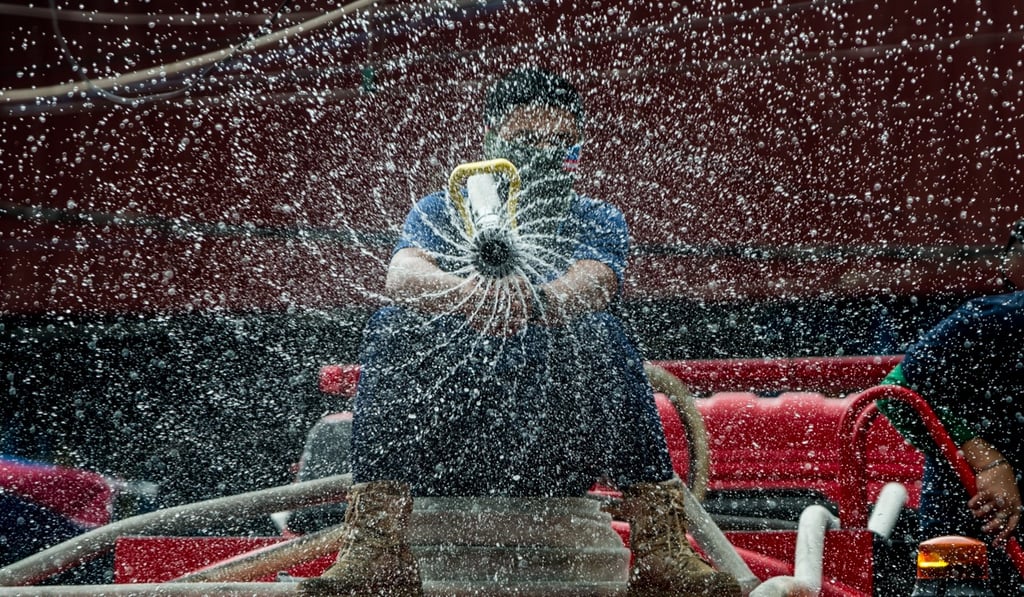 A worker sprays disinfectant along a street near a public market in Manila on Wednesday. Photo: DPA A worker sprays disinfectant along a street near a public market in Manila on Wednesday. Photo: DPA