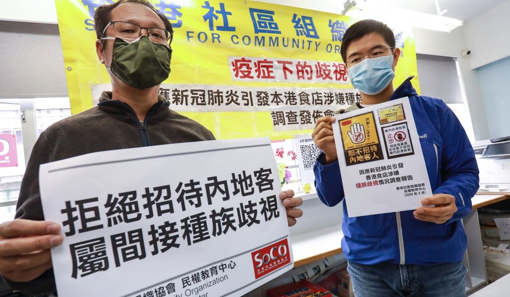 Richard Tsoi (left) holds slogans at the SoCO office in Sham Shui Po decrying discriminatory actions of businesses. Photo: May Tse
