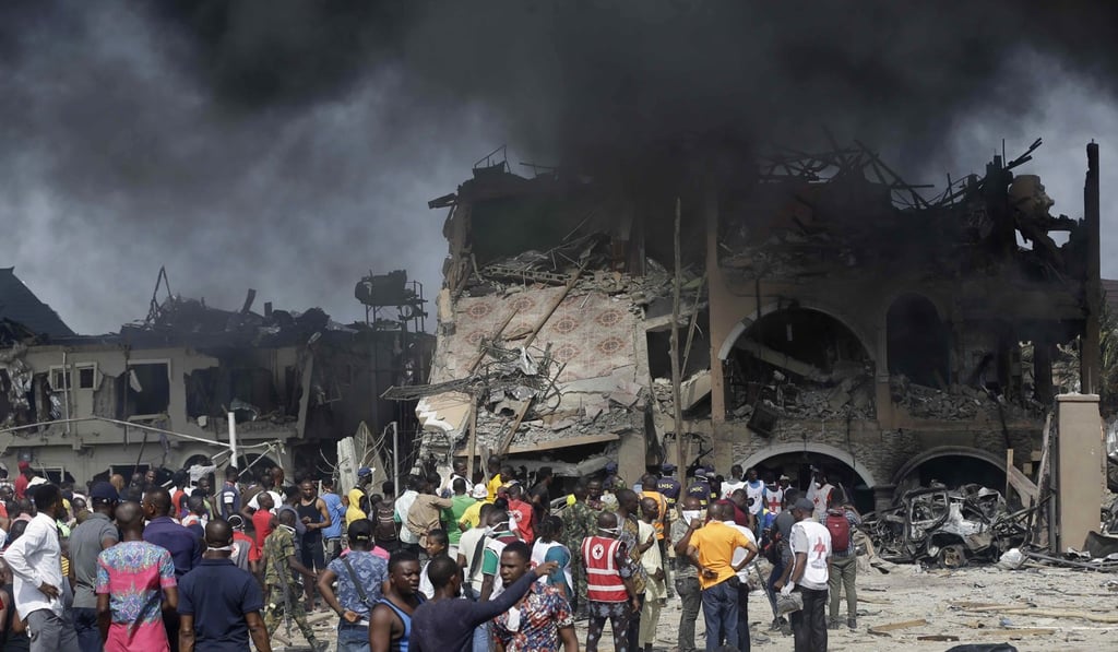 People gather near the site of an explosion in Lagos. Photo: AP Photo People gather near the site of an explosion in Lagos. Photo: AP Photo