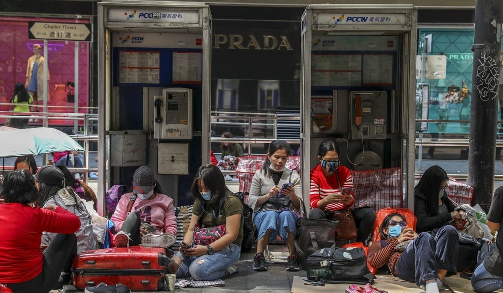 Foreign domestic workers, masked because of the ongoing coronavirus epidemic, gather on their day off in Central. Photo: Nora Tam