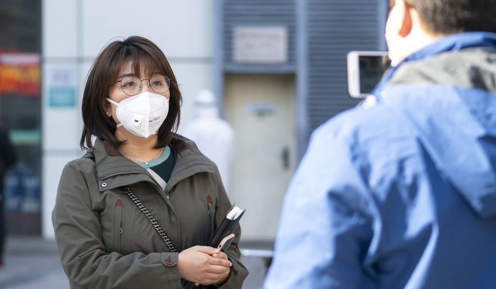 Xinhua reporter Liao Jun interviews a person outside Wuchang Hospital on February 18. Photo: Xinhua